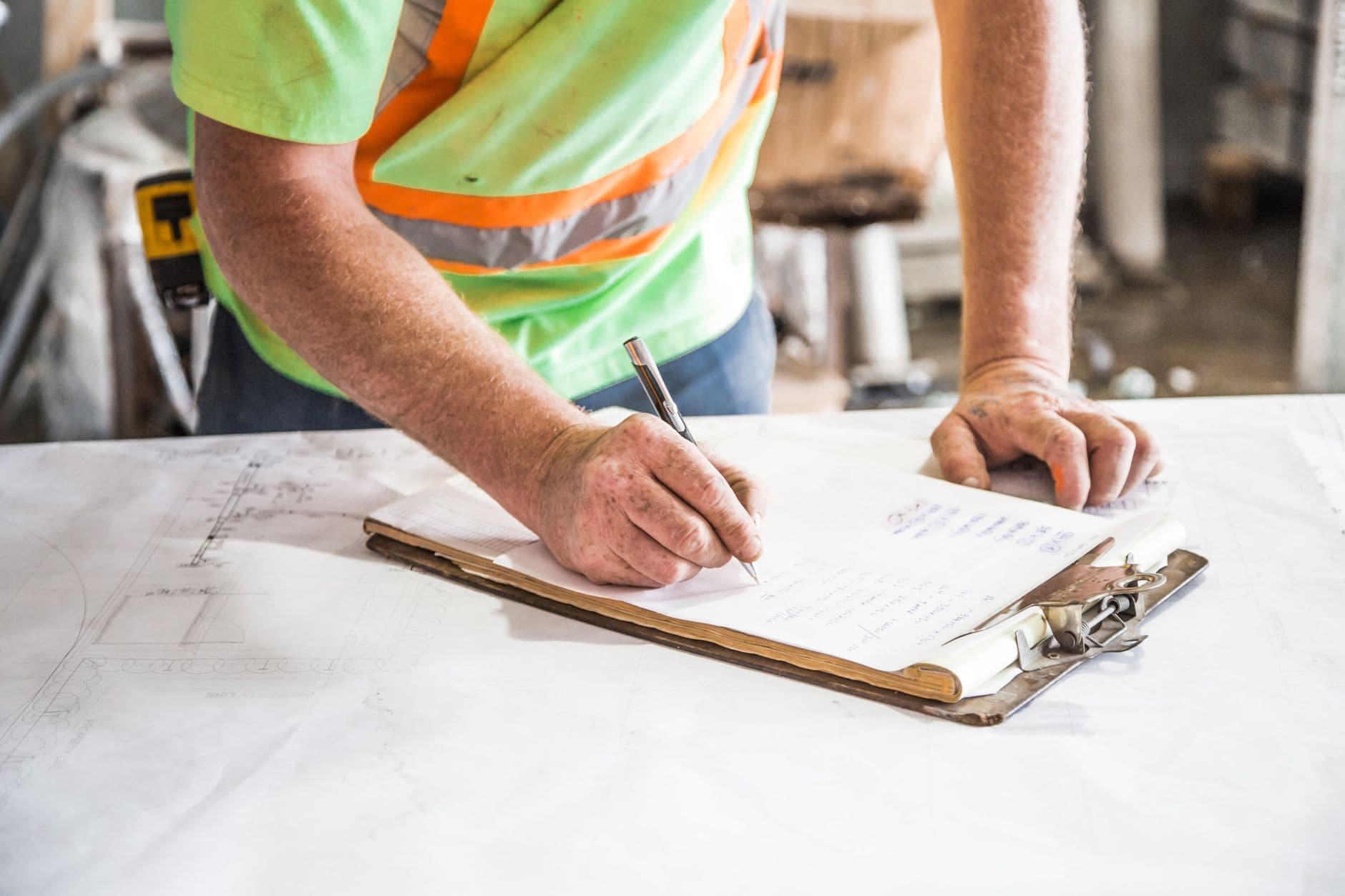 HSE inspector on a construction site reviewing documentation with a site manager