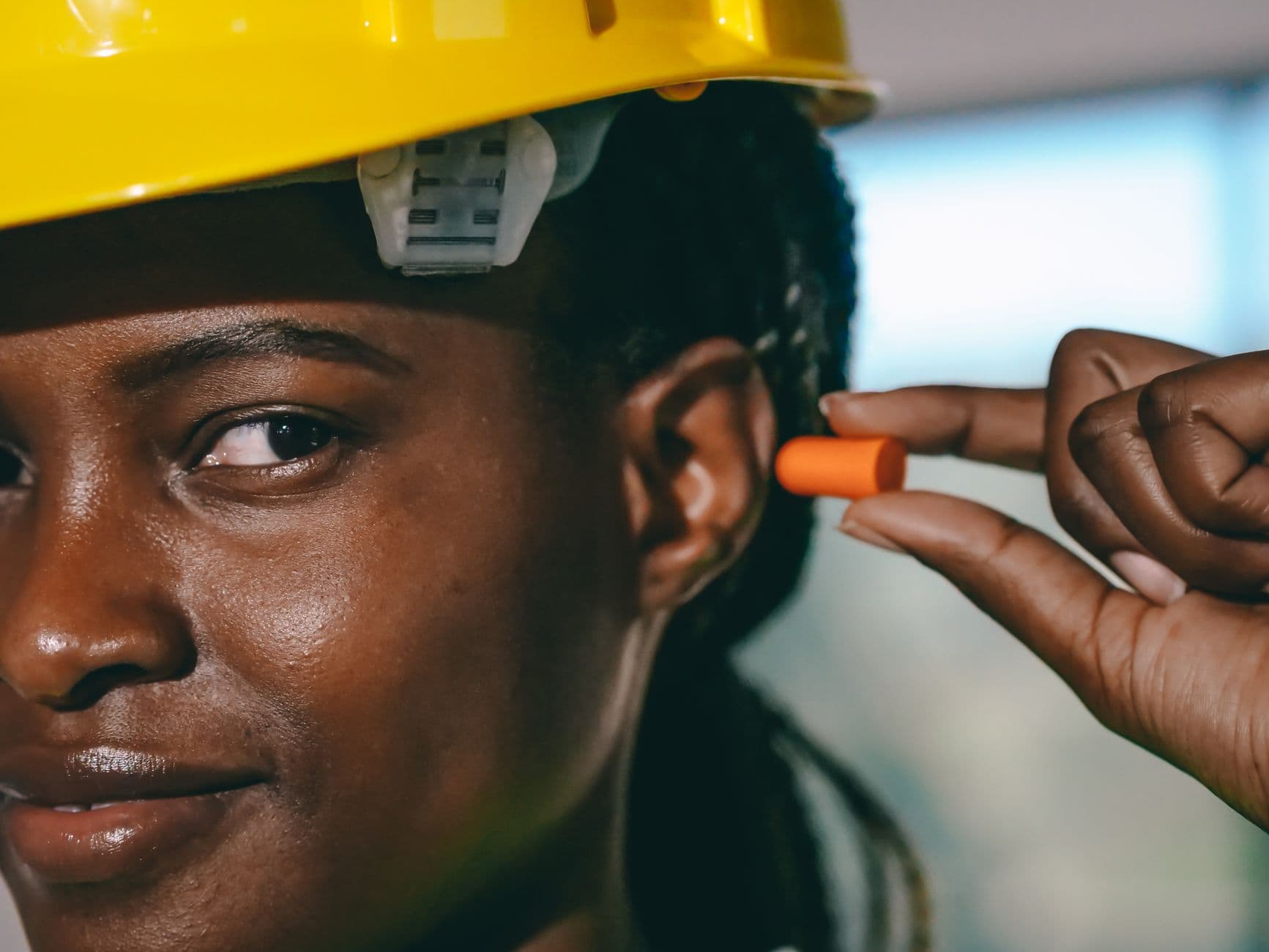 Construction worker wearing ear defenders operating a breaker on site