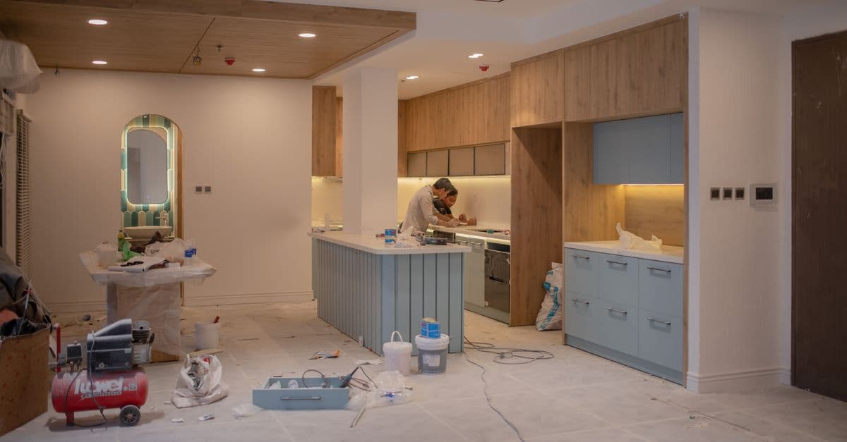 A kitchen fitter measuring a new worktop with safety equipment in place