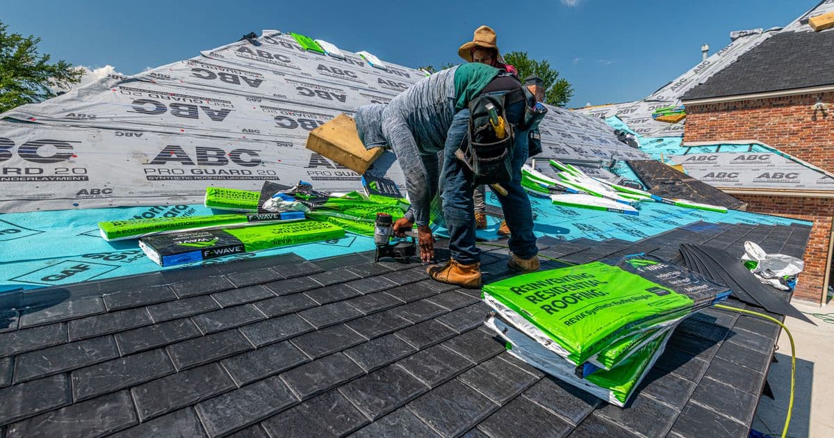 roofer carrying out a risk assessment on a domestic roof with scaffolding and edge protection in place