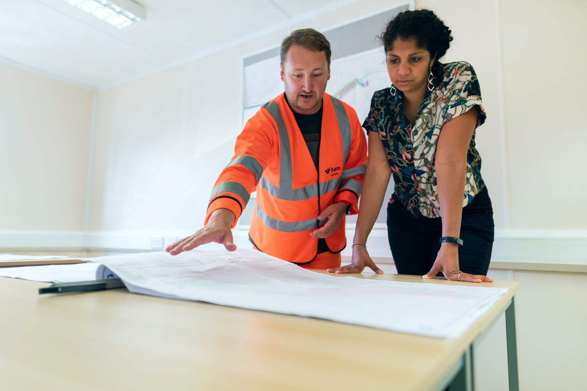 A site supervisor briefing workers on a construction site